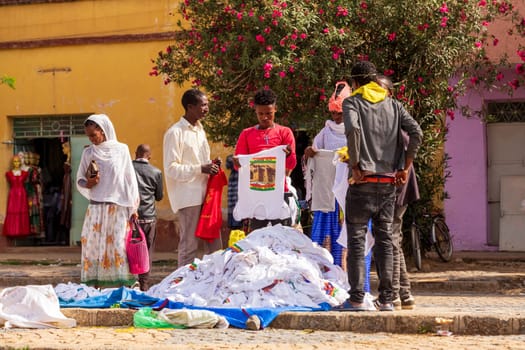 AXUM, ETHIOPIA, APRIL 27th.2019: Tigray native people in street market with clothes in center of Aksum on April 27, 2019 in Aksum, Tigray, Ethiopia Africa