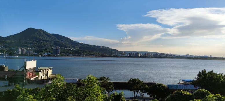 Tamsui, NEW TAIPEI CITY, TAIWAN - Sep 8, 2021 - City Tamsui Bali District in Taipei, Taiwan reflecting in the Tamsui River at nice day