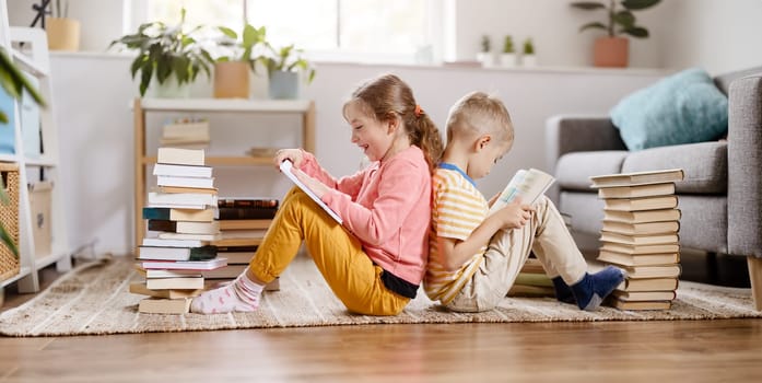 Two children sitting on the floor in the room and reading books- Concept of the family relationship, education and hobby.