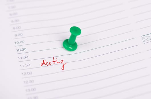 The word meeting is standing in a calendar, handwritten, needle pin
