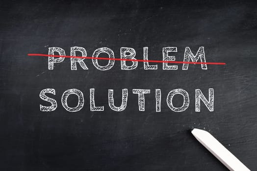 The words problem and solution are standing on a chalk board