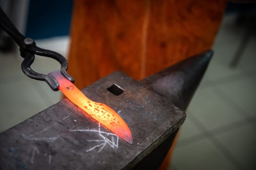 man hands are manufacturing a steel knife