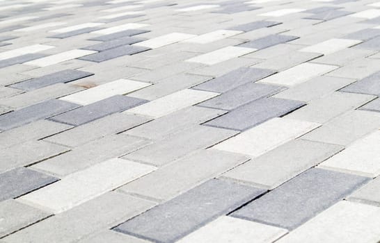 Concrete or paved newly laid gray paving slabs or stones for floors or walkways. Concrete paving slabs in the backyard or road paving. Garden brick path in the courtyard on a sandy foundation