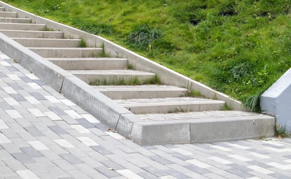 Steps from paving slabs and curbs. Rows of gray steps made of gray paving slabs are laid out evenly, consistently and tightly to each other. Paving stone steps slab gray background