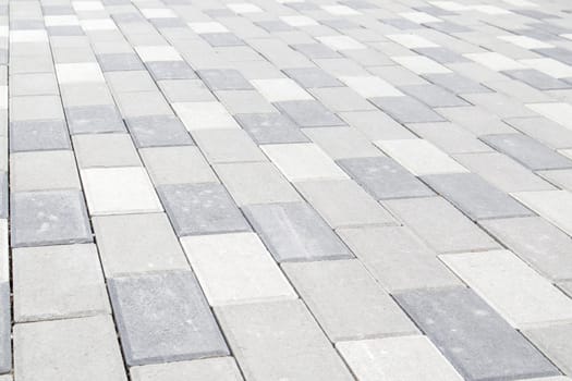 Concrete or paved newly laid gray paving slabs or stones for floors or walkways. Concrete paving slabs in the backyard or road paving. Garden brick path in the courtyard on a sandy foundation
