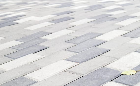 Concrete or paved newly laid gray paving slabs or stones for floors or walkways. Concrete paving slabs in the backyard or road paving. Garden brick path in the courtyard on a sandy foundation