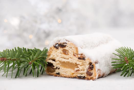 Christstollen, traditonal christmas cake with nuts, raisons, marzipan on a white background, empty space for text
