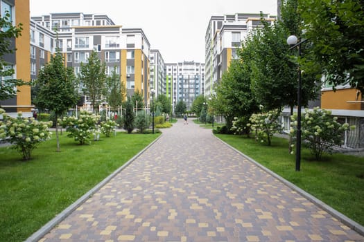 Apartment buildings in a new modern residential complex. Modern architecture. Social housing. The territory of a new residential area with tall buildings and large landscaping