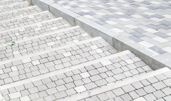 Steps from paving slabs and curbs. Rows of gray steps made of gray paving slabs are laid out evenly, consistently and tightly to each other. Paving stone steps slab gray background