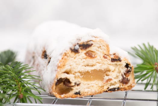 Christstollen, traditonal christmas cake with nuts, raisons, marzipan on a white background, empty space for text