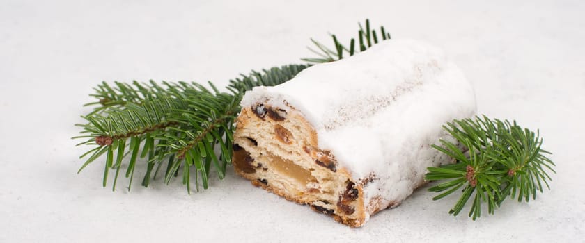 Christstollen, traditonal christmas cake with nuts, raisons, marzipan on a white background, empty space for text