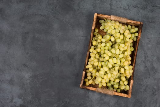 Grapes in a basket on a textured background, empty space for text