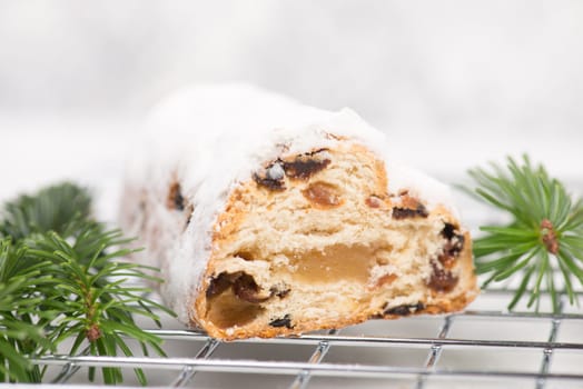 Christstollen, traditonal christmas cake with nuts, raisons, marzipan on a white background, empty space for text