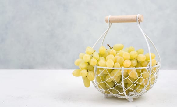 Grapes in a basket on a textured background, empty space for text
