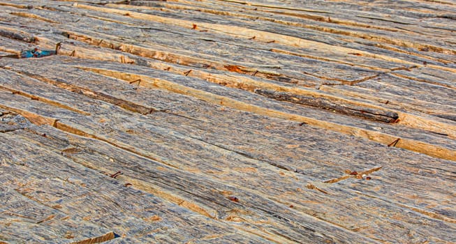 The background of an old natural wood room with messy and grungy floor texture inside empty neglected