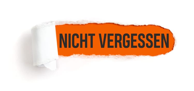 Hole in white paper with torns edges - Important in german - Nicht vergessen