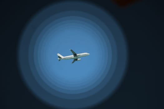 Plane flying high in sky. View to air liner flying in blue sky. Airplane seen in blue sky. Aerial panorama with aircraft in cloudless sky. Flying air liner