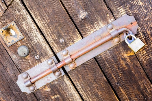 Old latch of a wooden door of a cow shed