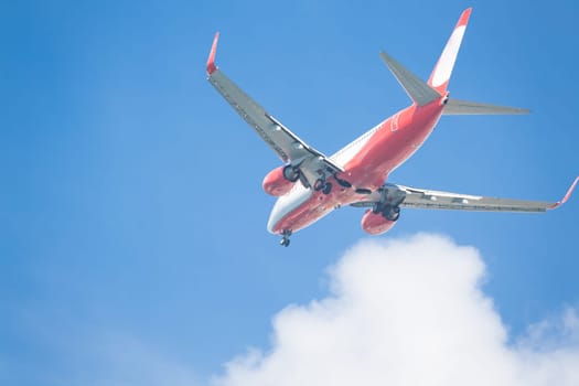 Plane Landing with blue sky and clouds in background.