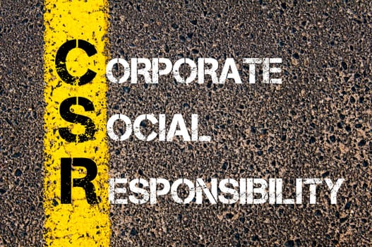 Acronym CSR - Corporate Social Responsibility.Business Conceptual image with yellow paint line on the road over asphalt stone background...