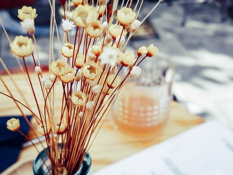 dried flowers with drinking glass in defocused background with copy space