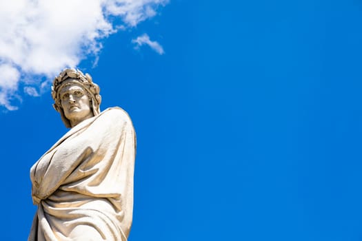 Dante Alighieri statue in Florence, Tuscany region, Italy, with an amazing blue sky background.