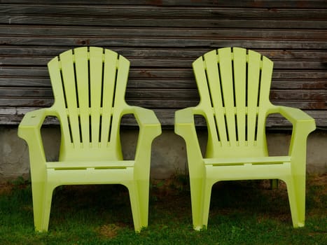 Two empty patio chairs in the back yard in the garden on green lawn grass, relax concept