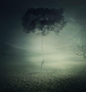 Conceptual scene, a man lifted up and manipulated by a dark cloud, symbol of pessimistic thoughts and depression. Mystic landscape with a lone person in a misty field. Scary halloween background