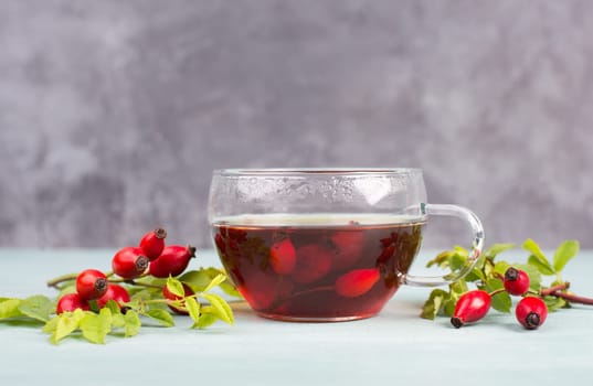 Hip rose tea with fresh fruits and leaves, hot drink