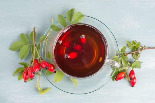 Hip rose tea with fresh fruits and leaves, hot drink