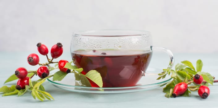 Hip rose tea with fresh fruits and leaves, hot drink