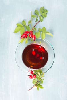 Hip rose tea with fresh fruits and leaves, hot drink