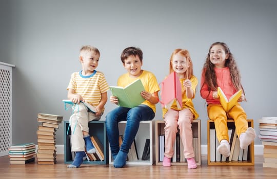 Group of children sitting on the book's stacks and on the bookshelves in the room and reading periodical. Concept of education and friendship.