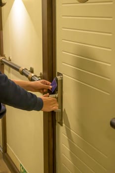 Close-up of a hand using a blue card key in a hotel door lock, key electronic lock, hotel room, holidays in mallorca, spain,