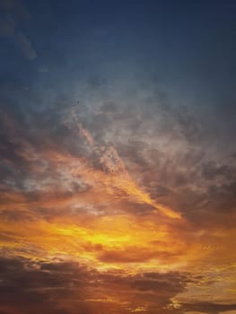 Autumn sunset sky. Vertical background, different colored  and shaped clouds and flocks of migratory birds flying. October seasonal celestial beauty. Panoramic dusk cloudscape scene