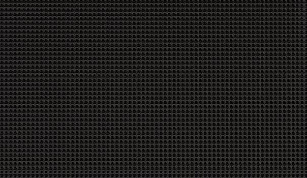 Spot lit perforated metal plate. Metal background close-up