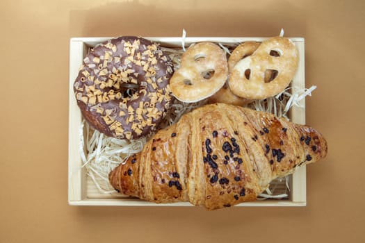 Fresh chocolate donut, croissant and cookies isolated on delicate coffee or brown background. Delicious desserts. Sweet food concept for your design and print. Top view, flat lay. Copy space