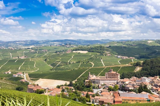 Panoramic countryside in Piedmont region, Italy. Scenic vineyard hill with the famous Barolo Castle and city.