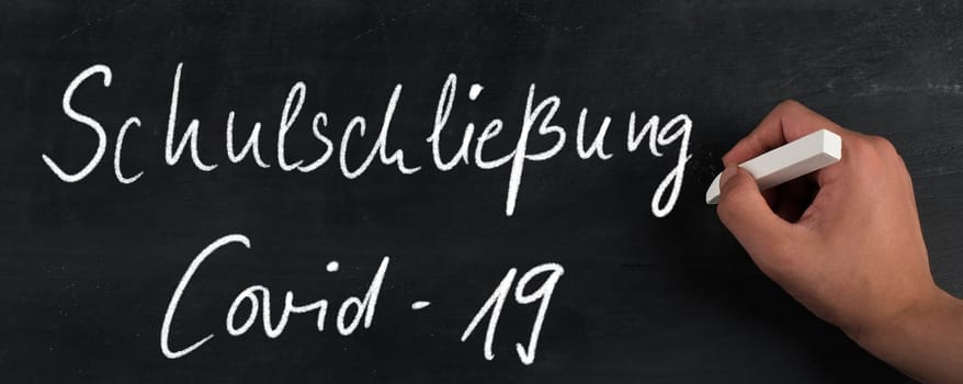 School closed because of Covid-19 is standing in german language on a chalkboard