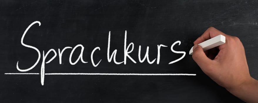 The words language course are standing in the german language on a blackboard
