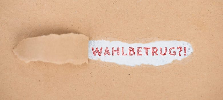 The german word for electoral fraud is standing on a torn paper