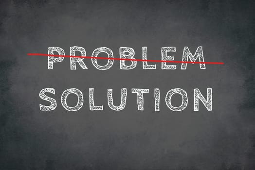 The words problem and solution are standing on a blackboard, written with chalk