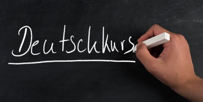 The words german lesson is standing in the german language on a blackboard