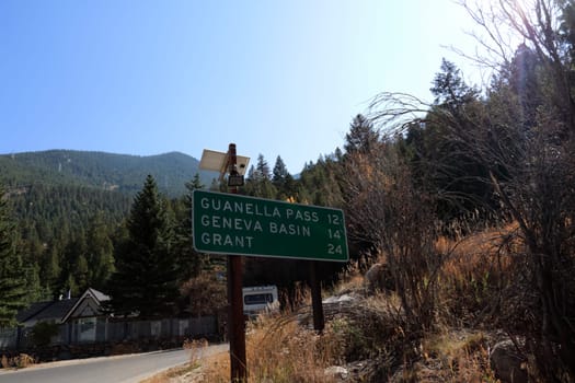 Georgetown, CO, USA - October 8, 2020: Road sign on Guanella Pass Rd, Co Rd 381, with miles to 3 towns ahead. Guanella Pass, Geneva Basin and Grant listed on a road sign with miles in the distance.