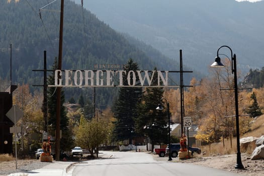 Georgetown, CO, USA - October 8, 2020: Large metal HISTORIC GEORGETOWN sign over Brownell St on way to Guanella Pass. Autumn decorations in the day with Historic Georgetown sign over Brownell St..