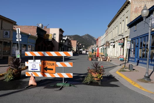 Idaho Springs, CO, USA - October 6, 2020: Barricades blocking off cars from driving historic downtown during the coronavirus pandemic. Early view of downtown street and buildings blocked off from traffic.