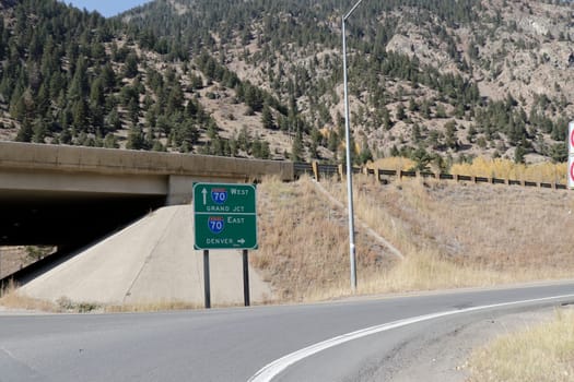 Georgetown, CO, USA - October 8, 2020: Directional road sign to entrances to Interstate 70. Pointing to the right would be east to Denver. Pointing forward under overpass goes west to Grand Junction.
