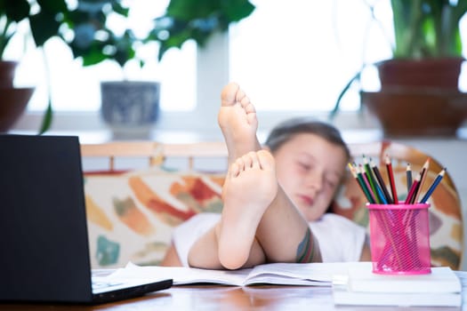 Distance learning-online education. School girl sleeping durng online education classes. COVID-19 pandemic forces children online learning.