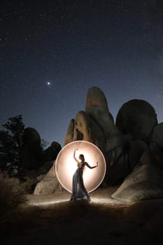 Light Painted Model Posing with Stars in Desert Setting