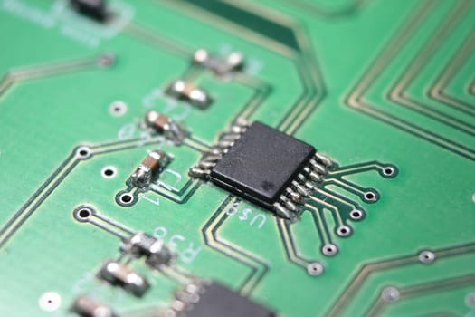 Electronic board with circuit lines and chip. Macro view of green board